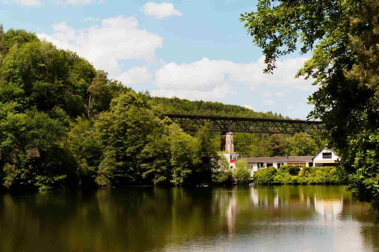 Historischer Eisenbahnviadukt über einem Stausee im Wald