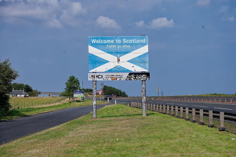 Strassenschild Welcome to Scotland mit schottischer Flagge an der Autobahngrenze